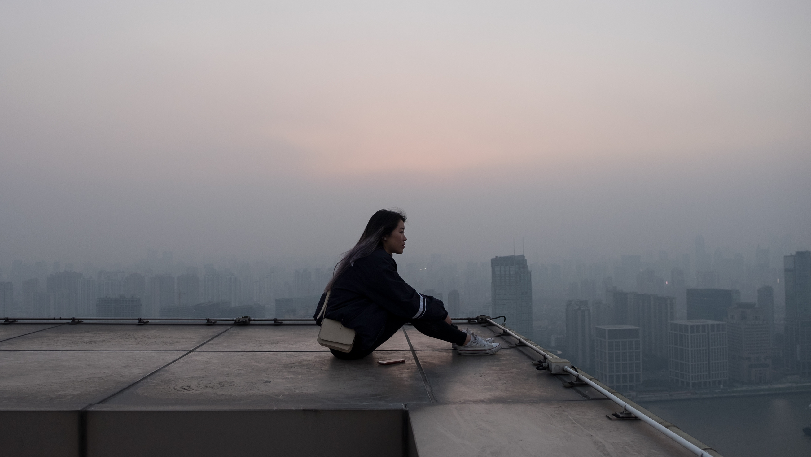 Woman Sitting on Top of a Building